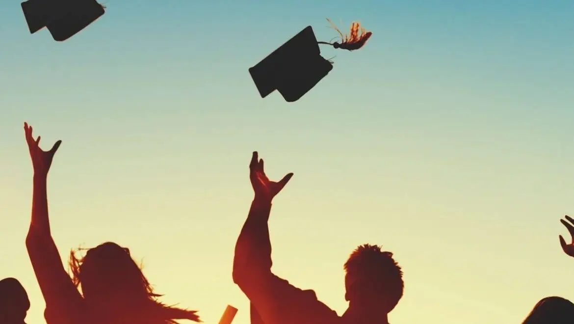 graduates tossing caps